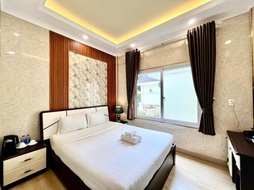 a bedroom with a large bed and a window at Savio Hotel Trieu Viet Vuong in Da Lat