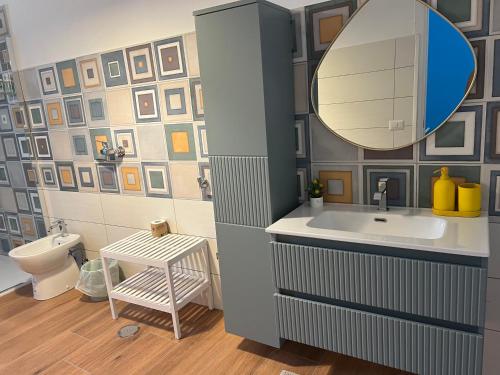 a bathroom with a sink and a mirror and a toilet at A Casa di Giuseppa Natura bio in Caserta