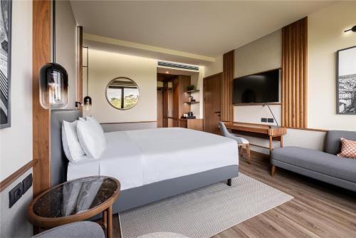 a hotel room with a white bed and a couch at Radisson Blu Hotel, Florence in Florence