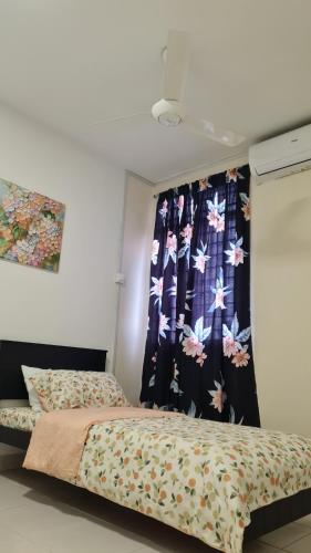 a bedroom with a bed and a curtain with flowers at EcoHill Serenity Suites in Semenyih
