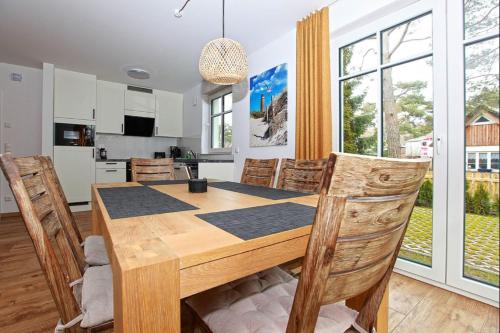 eine Küche und ein Esszimmer mit einem Holztisch und Stühlen in der Unterkunft Haus Eichkater in Dierhagen