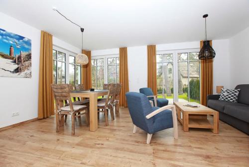 a living room with a table and chairs at Haus Eichkater in Dierhagen