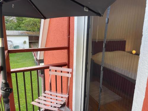 a balcony with a chair and an umbrella at Altmühlhäuschen in Mörnsheim