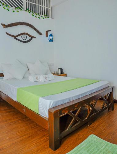 a bedroom with a bed with an eye on the wall at Ramya Ru Nature Resort in Galle