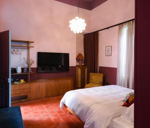 a bedroom with a bed and a flat screen tv at Villa Saf in Bharsaf