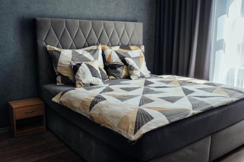 1 cama con edredón y almohadas en The Bašty Stay, en Brno