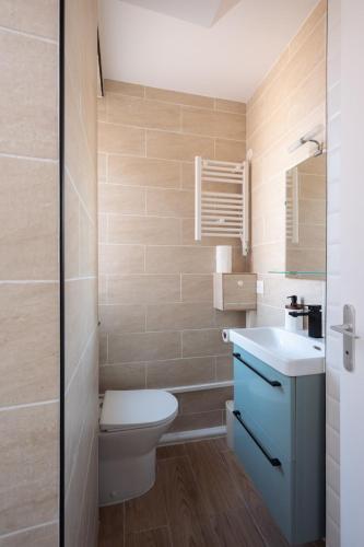 a bathroom with a toilet and a sink at Studio rénové - Accès direct Paris in Montreuil