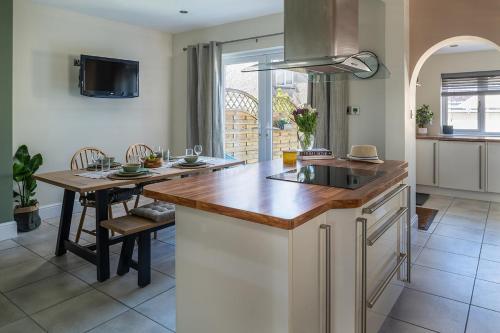a kitchen with a wooden counter top and a table at Modern 3 bedroom house Llanrwst less than a 5 minute drive from Zip World Forest in Llanrwst