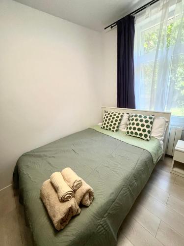 a bedroom with a green bed with towels on it at Garsoniera lângă Palatul Parlamentului in Bucharest