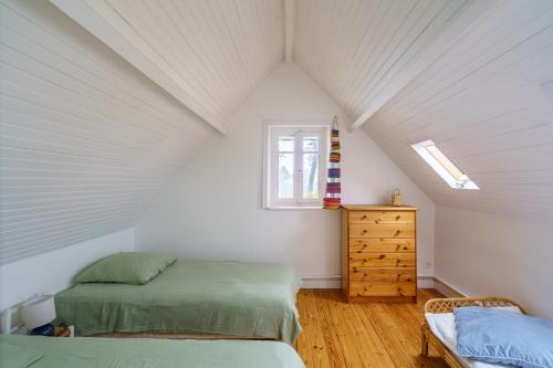 a attic bedroom with two beds and a dresser at Ker Gaïdic - Proche Plage in Bénodet