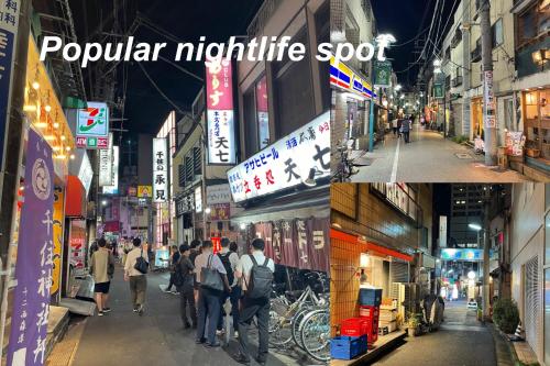 a group of people walking down a city street at night at Senjushuku FUJI 201 北千住 in Tokyo