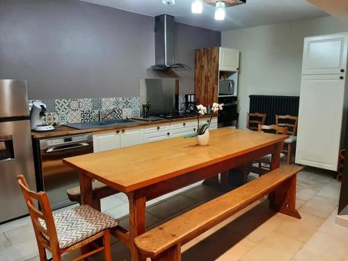 a kitchen with a wooden table and a wooden bench at Maison accueillante à Clermont-Créans, 70m² avec jardin in Clermont-Créans