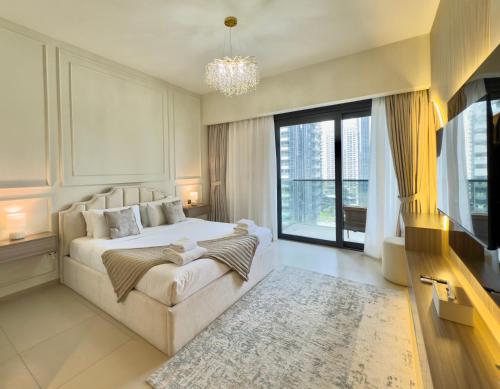 ein Schlafzimmer mit einem großen Bett und einem großen Fenster in der Unterkunft Iconic Burj Khalifa, Fountain Views, Luxury 2BR in Sabkhah