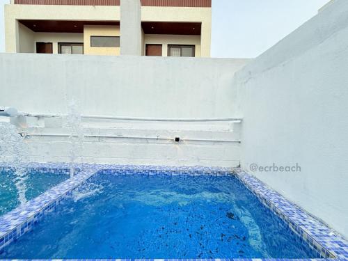 a swimming pool in front of a building at kishore villa in Mahabalipuram