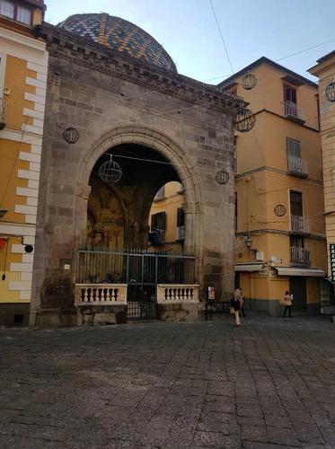 a building with an arch with benches in front of it at Garghe House in Sorrento