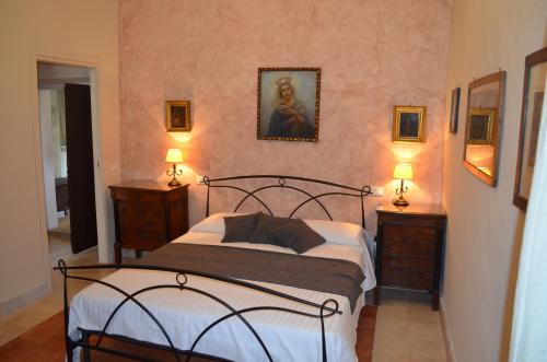 a bedroom with a bed with two dressers and two lamps at Casale Colleoni in Tivoli