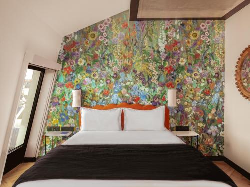 a bedroom with a large bed and a colorful wall at Chachacha Hôtel in Nantes