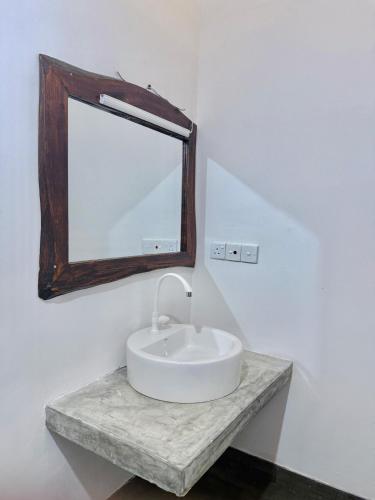 a white bathroom with a sink and a mirror at Ramya Ru Nature Resort in Galle