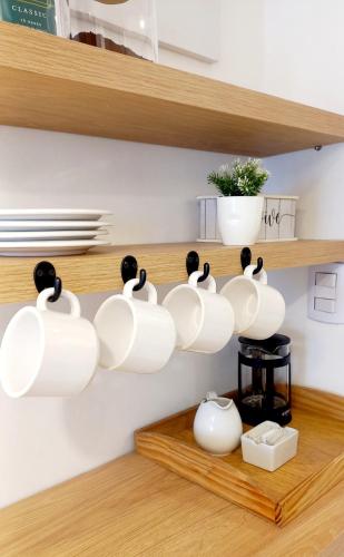 a group of white coffee cups on a shelf at Dpto Temporario Córdoba, ubicación ideal in Cordoba