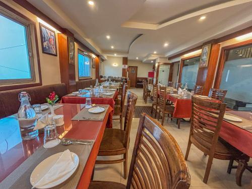 a dining room with tables and chairs in a restaurant at Rare Himalayas De Regency Pelling in Pelling