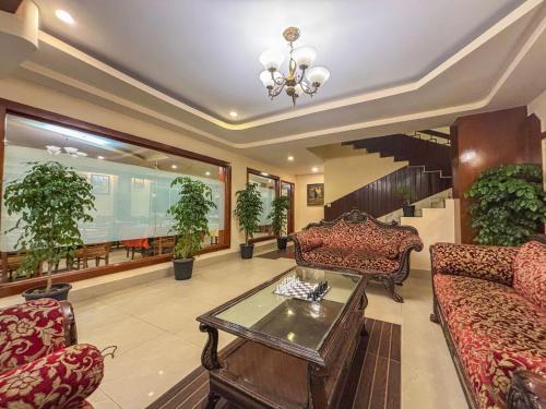 a living room with couches and potted plants at Rare Himalayas De Regency Pelling in Pelling
