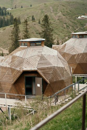 a group of wooden buildings on a hill at Pana Unique Kolsay in Kurmenty