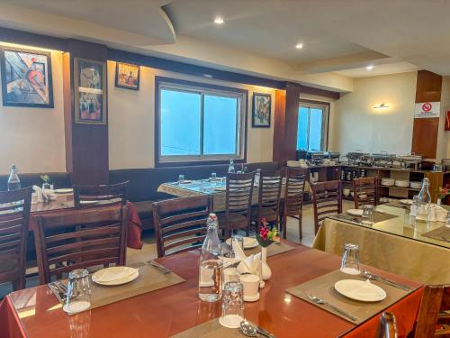 a dining room with tables and chairs in a restaurant at Rare Himalayas De Regency Pelling in Pelling