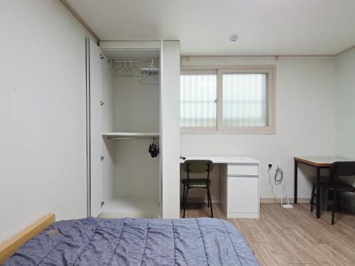 a bedroom with a bed and a desk and a table at J 9-minute walk from Nakseongdae Station, quiet neighborhood studio in Samgong