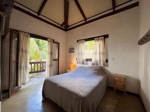a bedroom with a bed in a room with windows at Casa Yacht Club in Ilhabela