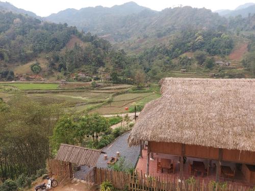 a house with a straw roof on a mountain at Tay Eco House in Ha Giang