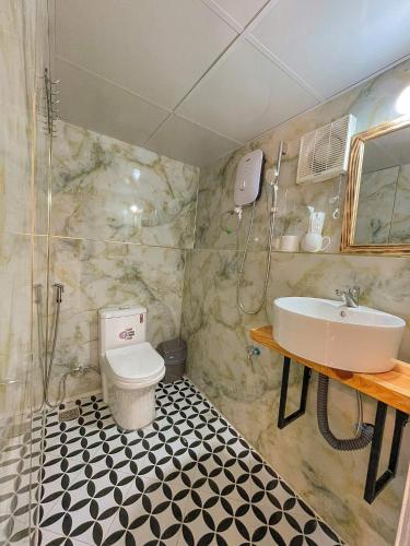 a bathroom with a sink and a toilet at Cuc ku homestay in Ấp Ða Lợi