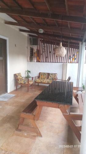a living room with a wooden table and benches at Casa Nativa Guajiru in Trairi