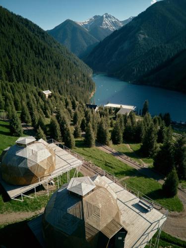 an aerial view of a building with a lake and mountains at Pana Unique Kolsay in Kurmenty