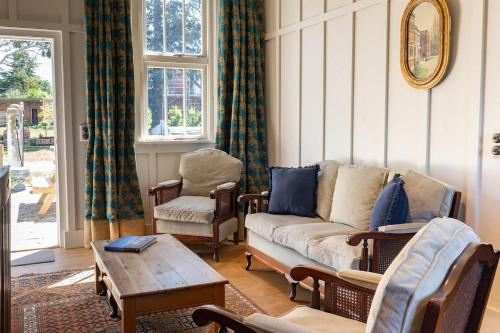 a living room with a couch and chairs and a table at Historic Castle Coach House in Earnscleugh