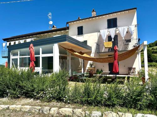 a house with a hammock in front of it at Oltrella Country House in Ponte Nizza