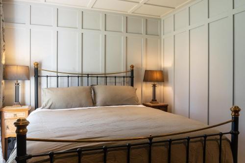 a bedroom with a large bed with two lamps at Historic Castle Coach House in Earnscleugh