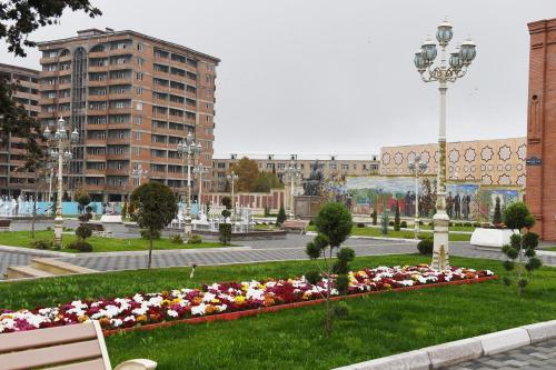 a park with flowers in the middle of a city at Backpackers Base in Ganja