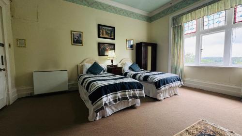 a bedroom with two beds and a window at Berthlwyd Country House in Conwy