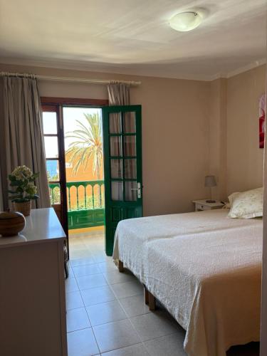 Un dormitorio con una cama y una ventana grande. en Apartamentos Guahedun, en Valle Gran Rey