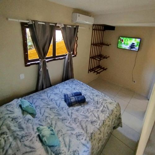 a bedroom with a bed and a window and a television at L&M Housing Apartamentos y casa in Búzios