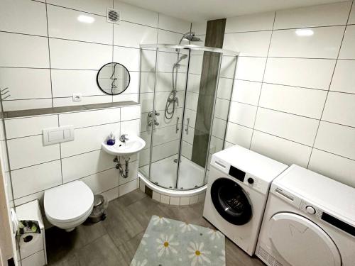 y baño con ducha, aseo y lavadora. en Modern Apartment with Balcony in Duisburg, en Duisburg