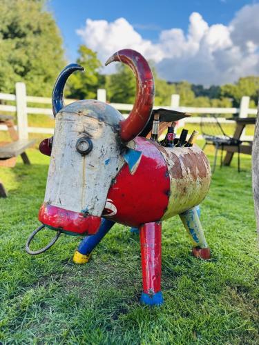 a statue of a metal bull on the grass at Entire Venue Hire with 8 Bedroom Accommodation - Your Own Pub Experience in Swansea