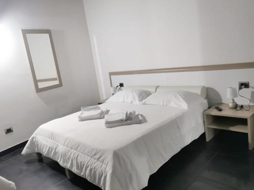 a white bed with two towels on top of it at Il Borgo Ospitale - Albergo Diffuso in Rotonda