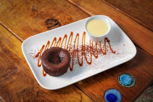 a plate with a chocolate donut with caramel sauce at Auberge de la fontaine aux loups in Saint-Sulpice-le-Dunois