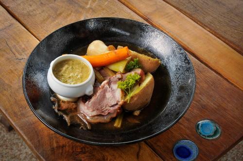 a plate of food with meat and vegetables and dipping sauce at Auberge de la fontaine aux loups in Saint-Sulpice-le-Dunois
