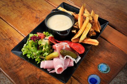 a plate of food with meat and french fries and dip at Auberge de la fontaine aux loups in Saint-Sulpice-le-Dunois