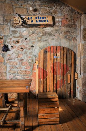 a wooden bench sitting in front of a wall with a sign at Auberge de la fontaine aux loups in Saint-Sulpice-le-Dunois