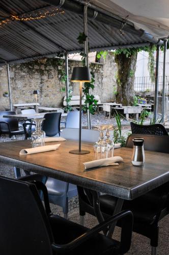 a wooden table with wine glasses on top of it at Auberge de la fontaine aux loups in Saint-Sulpice-le-Dunois