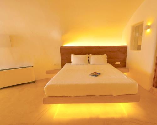 a bedroom with a large bed with lights on it at Chic Hotel Santorini in Firostefani