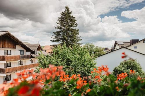 a tree in the middle of a yard with flowers at Appartementhaus Absmeier in Bad Füssing